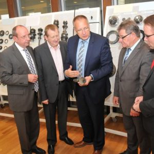 Wolfgang Decker, Günter Rudolph, Uwe Frankenberger und Timon Gremmels lassen sich von Werksleiter Falko Rudolph (Mitte) eine Auswahl von in Baunatal gefertigten modernsten Komponenten zeigen.